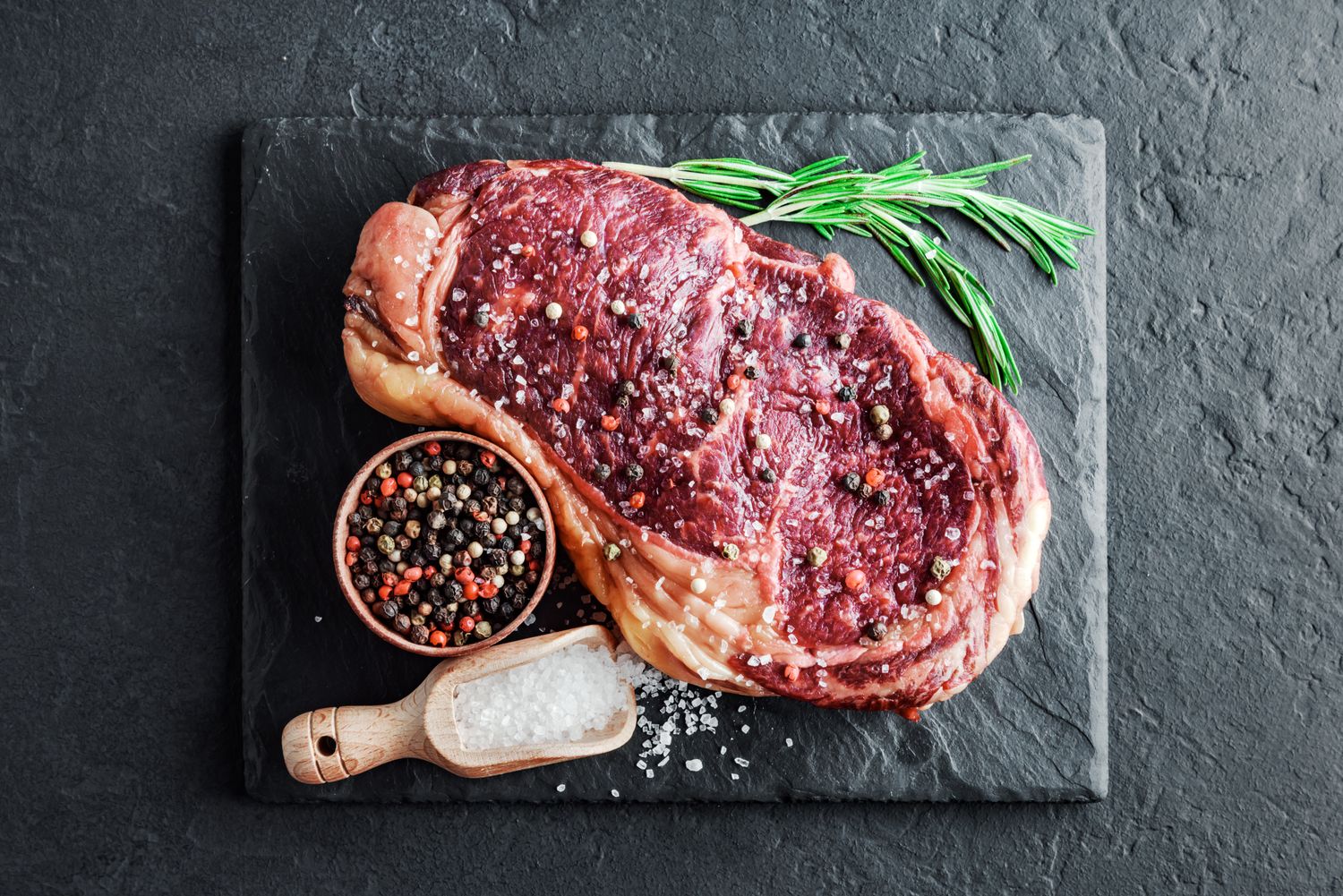 Marbling ribeye steak on slate board. Prime rib beef chop. Food photography